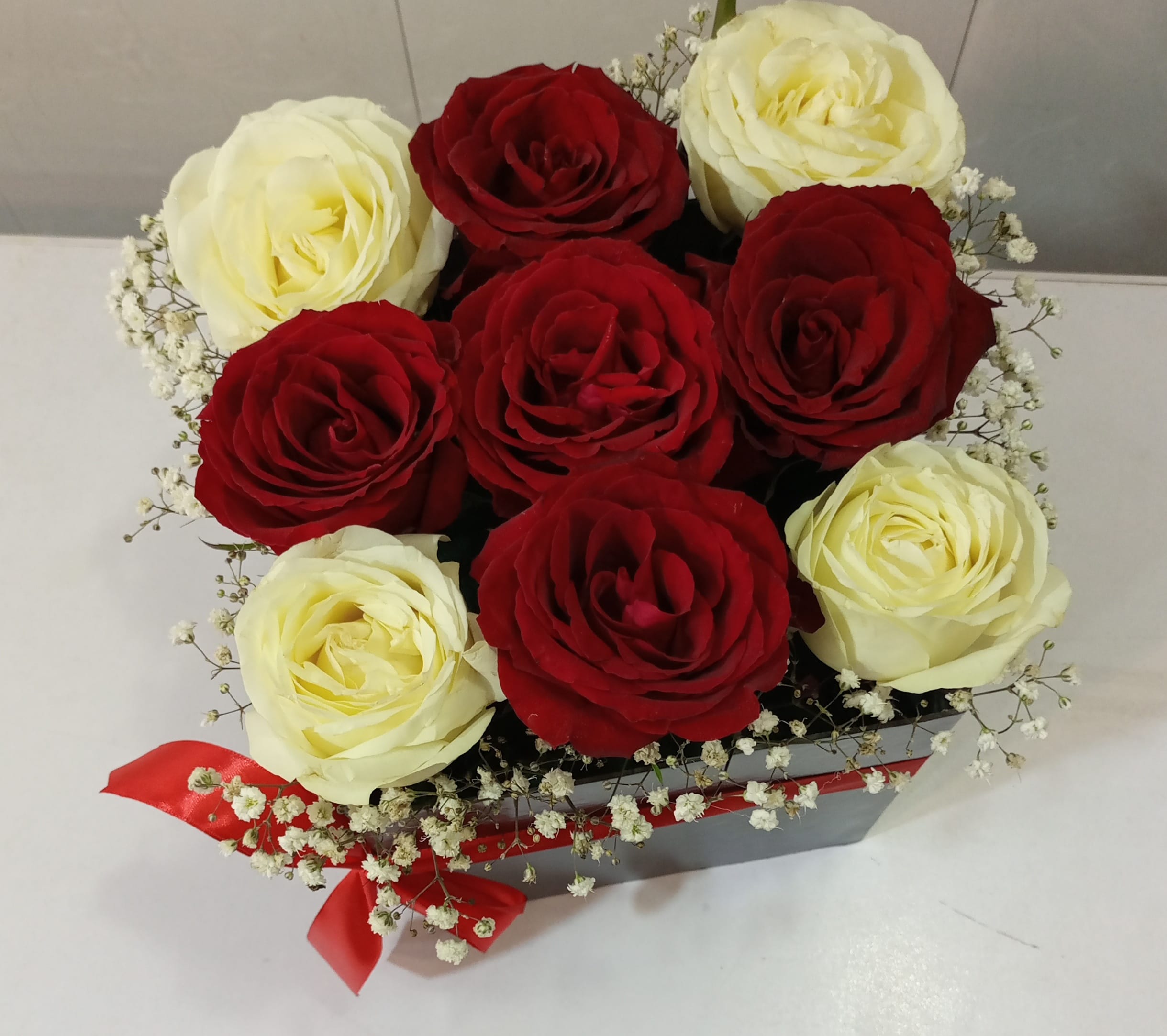 Elegant Touch – 5 Red Roses, 4 White Roses, Imported Flower & Baby’s Breath Gift Basket